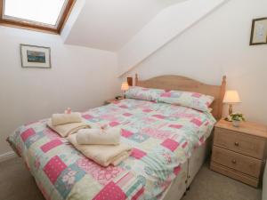 a bedroom with a bed with towels on it at Exchange Cottage in Tideswell