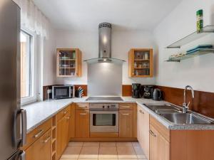 a kitchen with wooden cabinets and a sink at Apartment with private terrace in Velmede in Bestwig