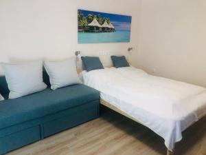 une chambre avec deux lits et un canapé dans l'établissement Szieszta Szófia Apartman, à Harkány