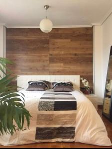1 dormitorio con 1 cama grande y pared de madera en Villa turística Camina y Rioja en Cenicero