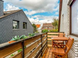 een balkon met een houten tafel en een stoel bij Cozy Apartment in P hlde With Sauna in Herzberg am Harz