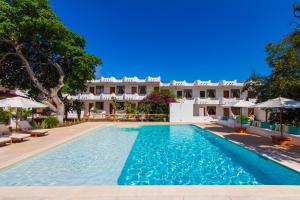 a swimming pool with a hotel in the background at Hotel Fiesta in Puerto Ayora