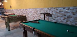 a pool table in a room with a brick wall at Pousada Chácara Kumbaya - Biritiba Mirim in Biritiba-Mirim