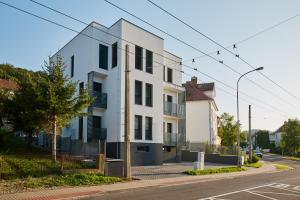 un edificio blanco al lado de una calle en Ella Apartments, en Zlín