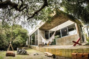 a house with a swing in front of it at CASA LOBO - La Pedrera -Luxury- Diseño junto al Mar in La Pedrera