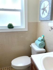 a bathroom with a toilet and a sink and a window at Hollywood Beach Apartments - Walk to the Beach in Hollywood +21 photos