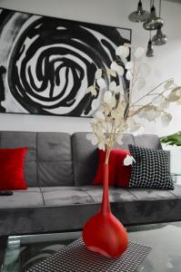 a red vase with white flowers in a living room at Cozy Stays Cayala Apartments 2 in Guatemala