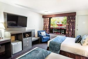 a hotel room with two beds and a flat screen tv at Bayshore Inn & Spa in Waterton Park
