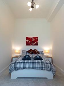 a bedroom with a bed with two lamps on both sides at Dumbarton Castle Way in Dumbarton