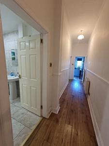 an empty hallway with a white door and a sink at Dumbarton Castle Way in Dumbarton