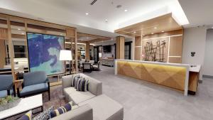 a lobby with a couch and chairs and a large screen at Hyatt House Oak Brook in Oak Brook