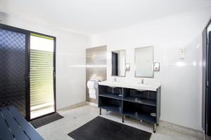 a bathroom with a large mirror and a sink at Mycow Accommodation Mackay in Mackay