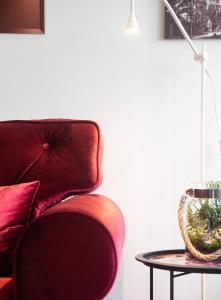 a living room with a red chair and a table at Rose Valley Apartment in Polanica-Zdrój