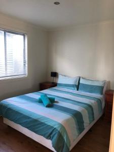 a bedroom with a large bed with blue pillows at Koonwarra Holiday Park in Lakes Entrance