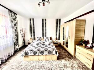ein Schlafzimmer mit einem Bett mit einer schwarzen und weißen Decke in der Unterkunft Amazing House Cazare in Sibiu