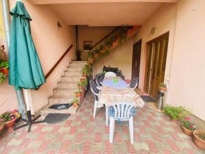 eine Terrasse mit einem Tisch und einem grünen Sonnenschirm in der Unterkunft Amazing House Cazare in Sibiu