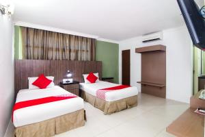 a bedroom with two beds with red pillows at Crystal City Hotel in Kuantan