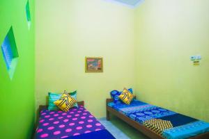Postel nebo postele na pokoji v ubytování OYO 2440 Wallet Family Residence Syariah