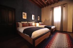 a bedroom with two beds and a window at Antigua Trece Hotel Fusión in Guanajuato