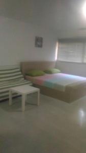 a bedroom with two beds and a table in it at Airport Transfer Bangkok apartment in Thung Si Kan