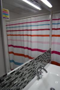 a bathroom with a white sink and a mirror at Alojamientos Villarias Murcia in Murcia