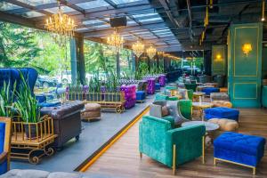 a lobby with chairs and tables and plants at Swiss-Belhotel Kendari in Kendari