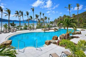 una piscina en un complejo con palmeras en Beachfront Hamilton Island en Isla Hamilton
