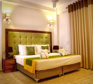 a bedroom with a large bed with towels on it at Vendol Maliga Edge in Kandy