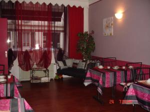 a living room with two tables and a couch at Hôtel de La Marmotte in Niort