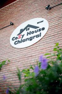 a sign on the side of a brick building at CoZy House Chiangrai in Chiang Rai