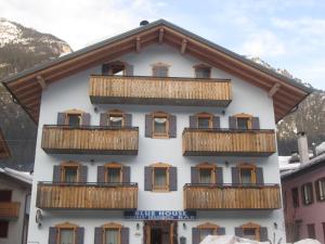 un edificio con balcones de madera en una montaña en Meublè Blue House, en Auronzo di Cadore