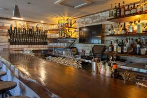 a bar with a wooden counter with bottles of alcohol at Crowne Plaza Fredericton Lord Beaverbrook by IHG in Fredericton