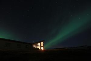 a building with the aurora in the sky at night at Hotel Gullfoss in Haukadalur