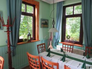 a dining room with a table and chairs and windows at Rhodaer Grund in Erfurt