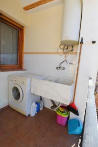 y baño con lavabo y lavadora. en Apartamentos Rurales San Juan, en Castellnovo