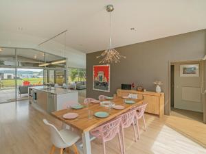 a dining room and kitchen with a table and chairs at Sanctuary By The Water - Matarangi Holiday Home in Matarangi