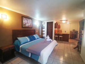 a bedroom with a bed with a teddy bear sitting on it at Terraza Suites - Adults Only in San Cristóbal de Las Casas