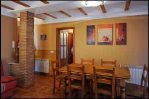 Un comedor con mesa y sillas de madera. en Apartamentos Rurales San Juan, en Castellnovo