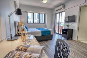um quarto de hotel com uma cama e uma mesa com copos de vinho em Central Brunswick Apartment Hotel em Brisbane