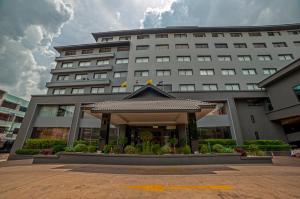 um grande edifício com um gazebo em frente em Le cassia Hotel em Khon Kaen