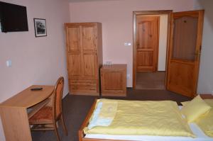 a bedroom with a bed and a desk and a table at Hotel Na Statku in Nepřevázka