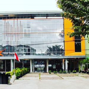 un gran edificio de cristal con una bandera delante de él en Xtra Hotel Bengkulu en Bengkulu