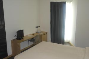 a bedroom with a bed and a desk with a television at Gobeo Park in Vitoria-Gasteiz