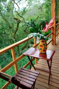 a wooden deck with a table and a vase with flowers at Reserva Azul in Cuetzalán del Progreso