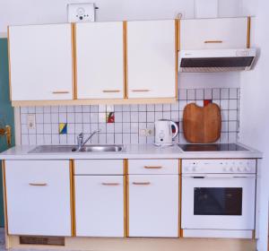 a kitchen with white cabinets and a sink at Sonnenheim in Forchach