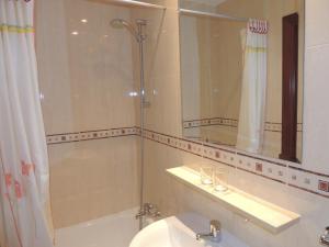 y baño con bañera, lavamanos y ducha. en Hostal Gonzalo, en Madrid