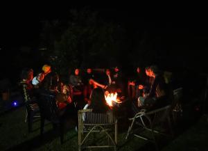 a group of people sitting around a fire at night at Gite etape chez Paule et jo in La Possession