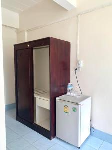 a small refrigerator in a room next to a wall at J-2 Court in Songkhla