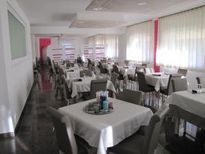 a dining room with tables and chairs in it at Hotel Scaranò in Levico Terme