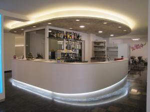 a lobby with a large white counter in a room at Hotel Scaranò in Levico Terme